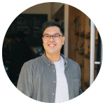 Portrait of the Director of Coffee smiling in a circular headshot with a blurred cafe interior background