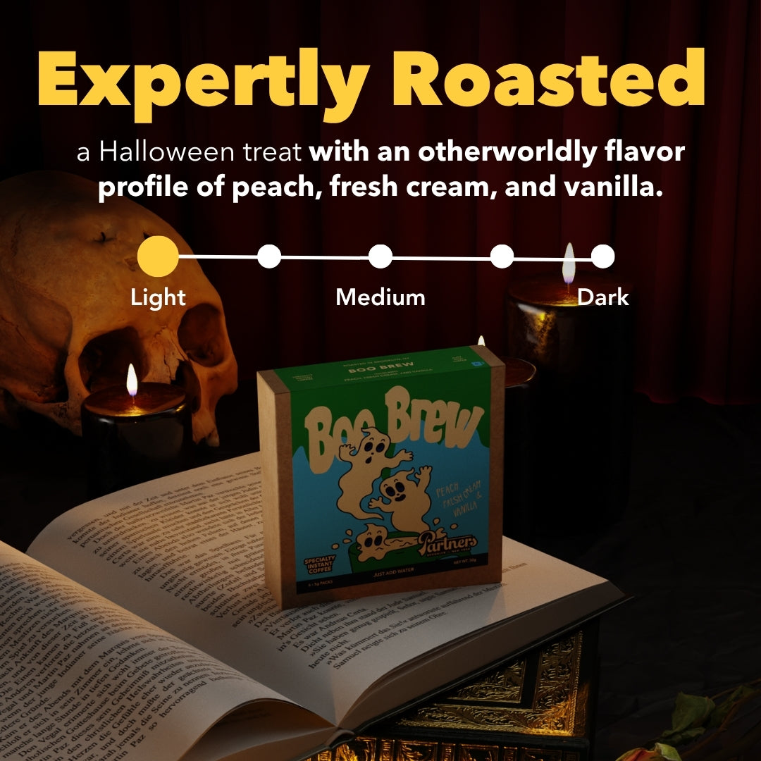 Front view of Boo Brew instant coffee box showcasing Expertly Roasted with peach, vanilla, and fresh cream in a Halloween setting