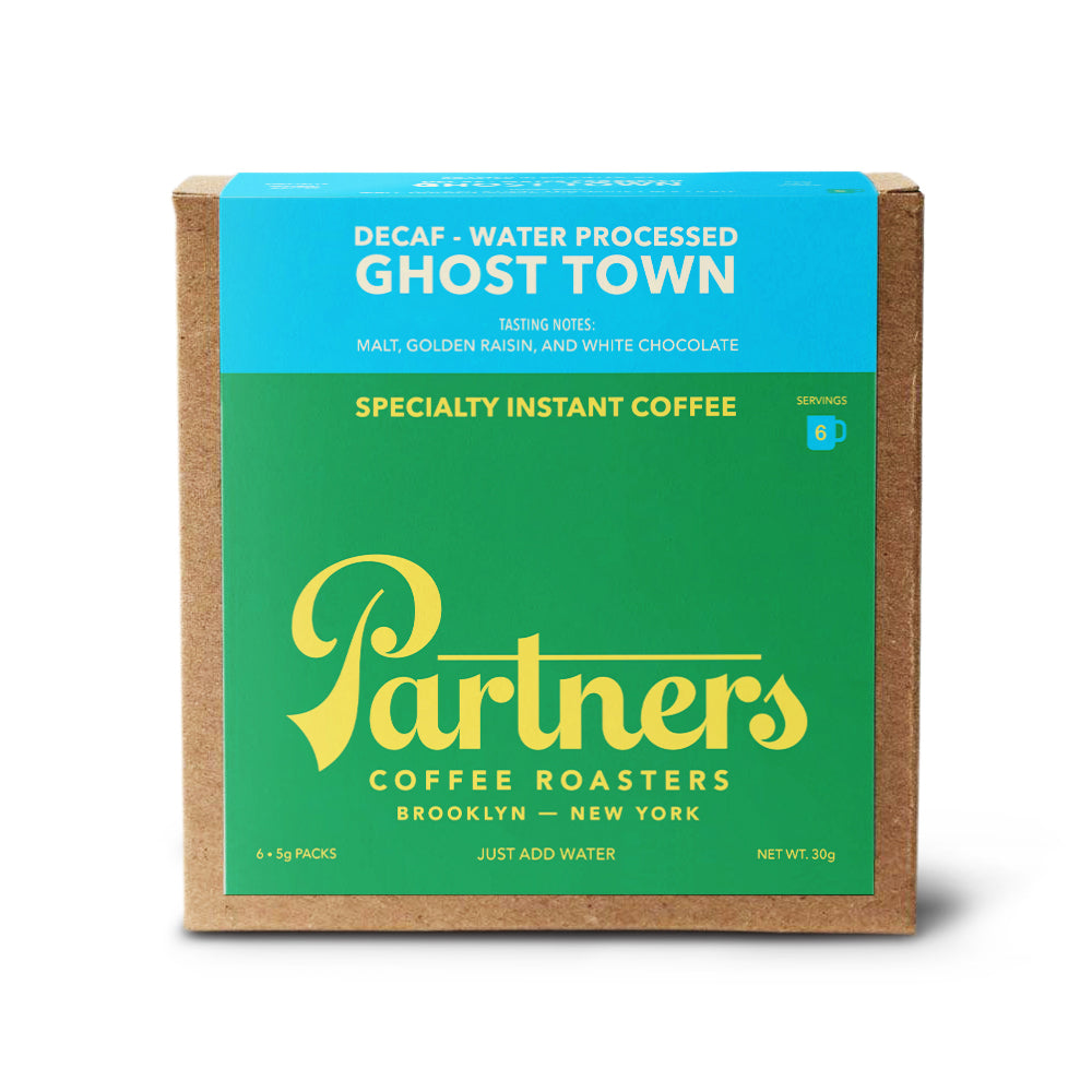 Front view of Ghost Town decaf specialty instant coffee box showing green and turquoise packaging and Partners logo on white background