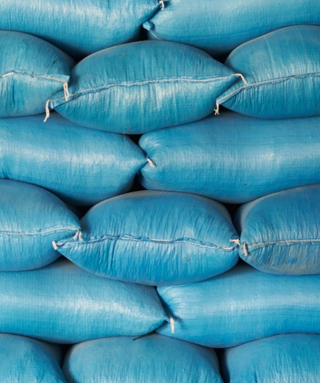 Stacked blue coffee sacks in a storage area