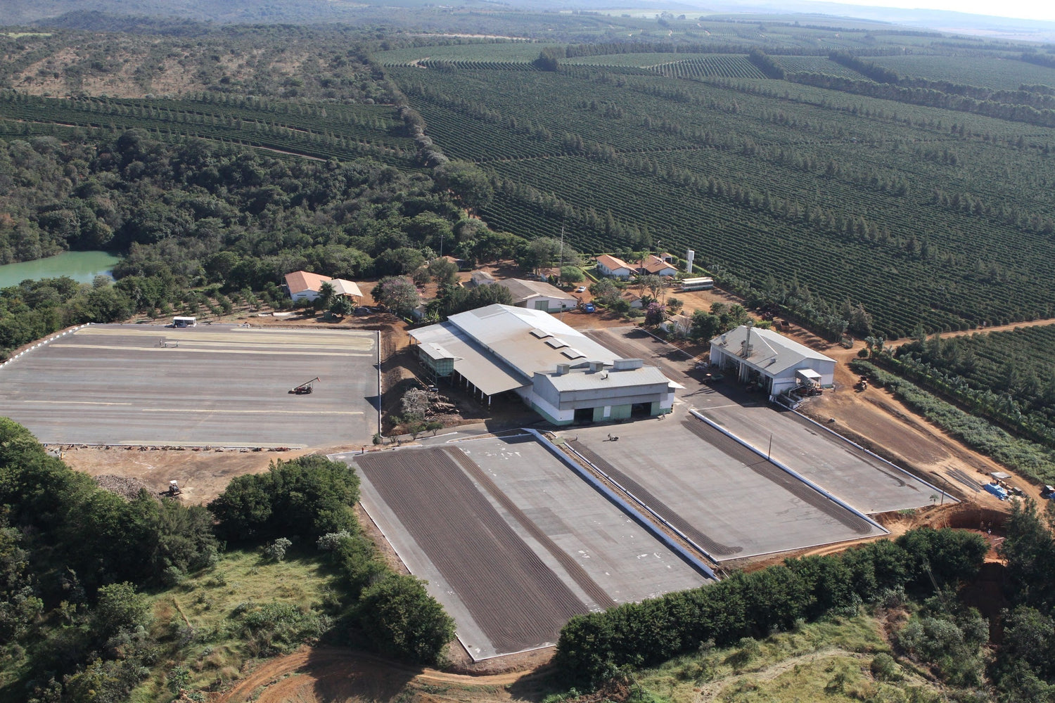 Aerial view of a coffee plantation and processing facility in Brazil surrounded by rolling farmland