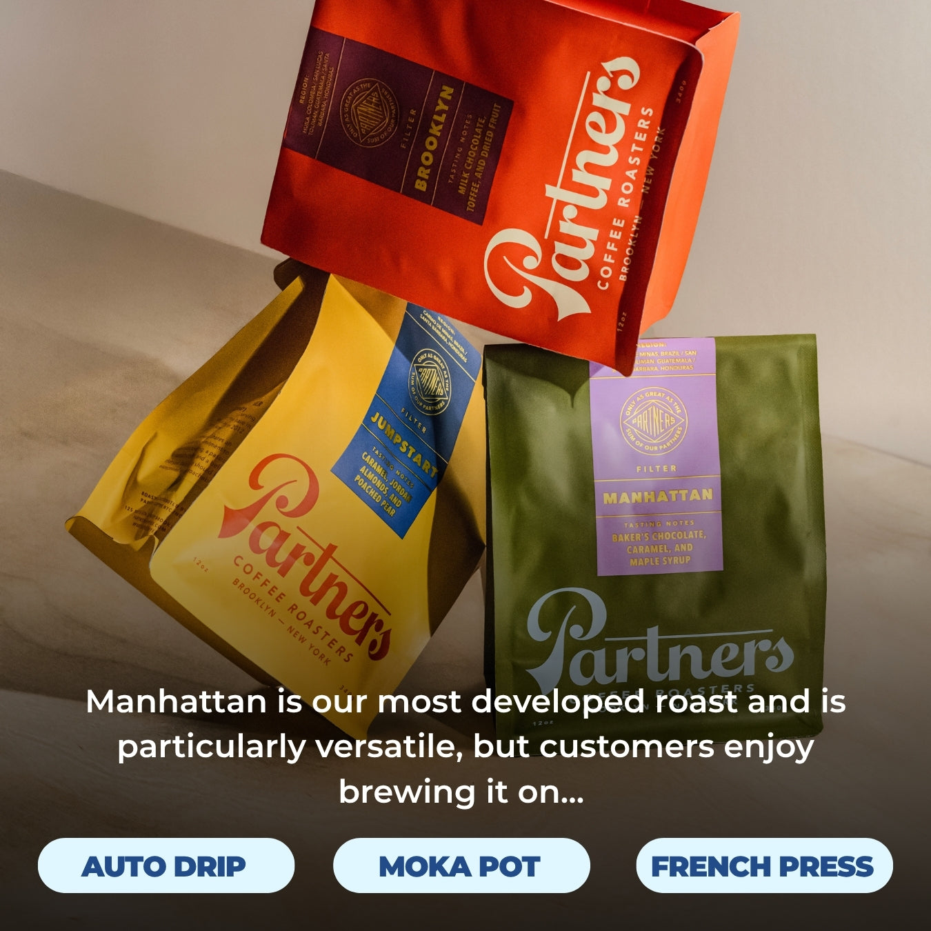 Angled view of Manhattan coffee bags showing three colorful bags with overlay reading Manhattan is our most developed roast