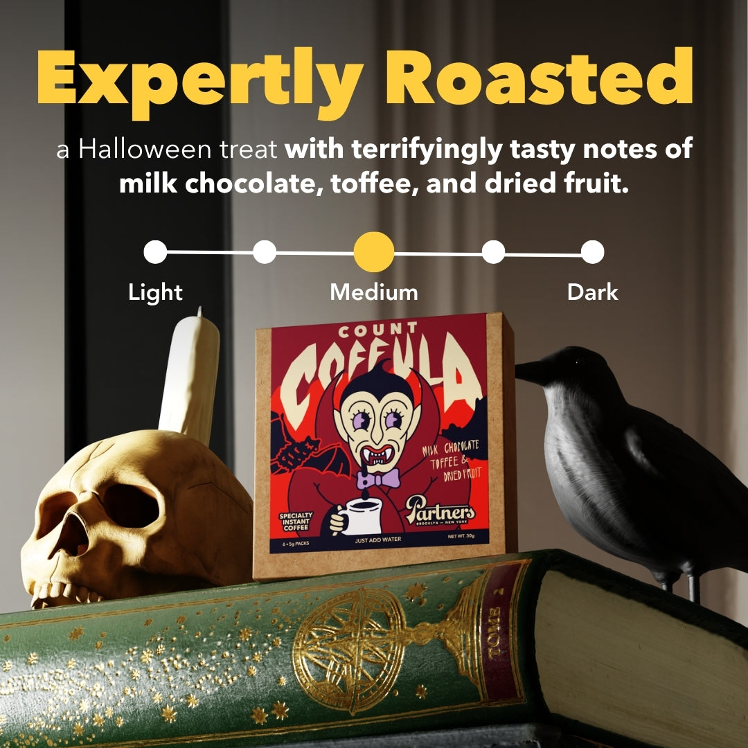 Front view of Count Coffula specialty instant coffee box with medium roast scale, skull, raven, and Halloween-themed packaging