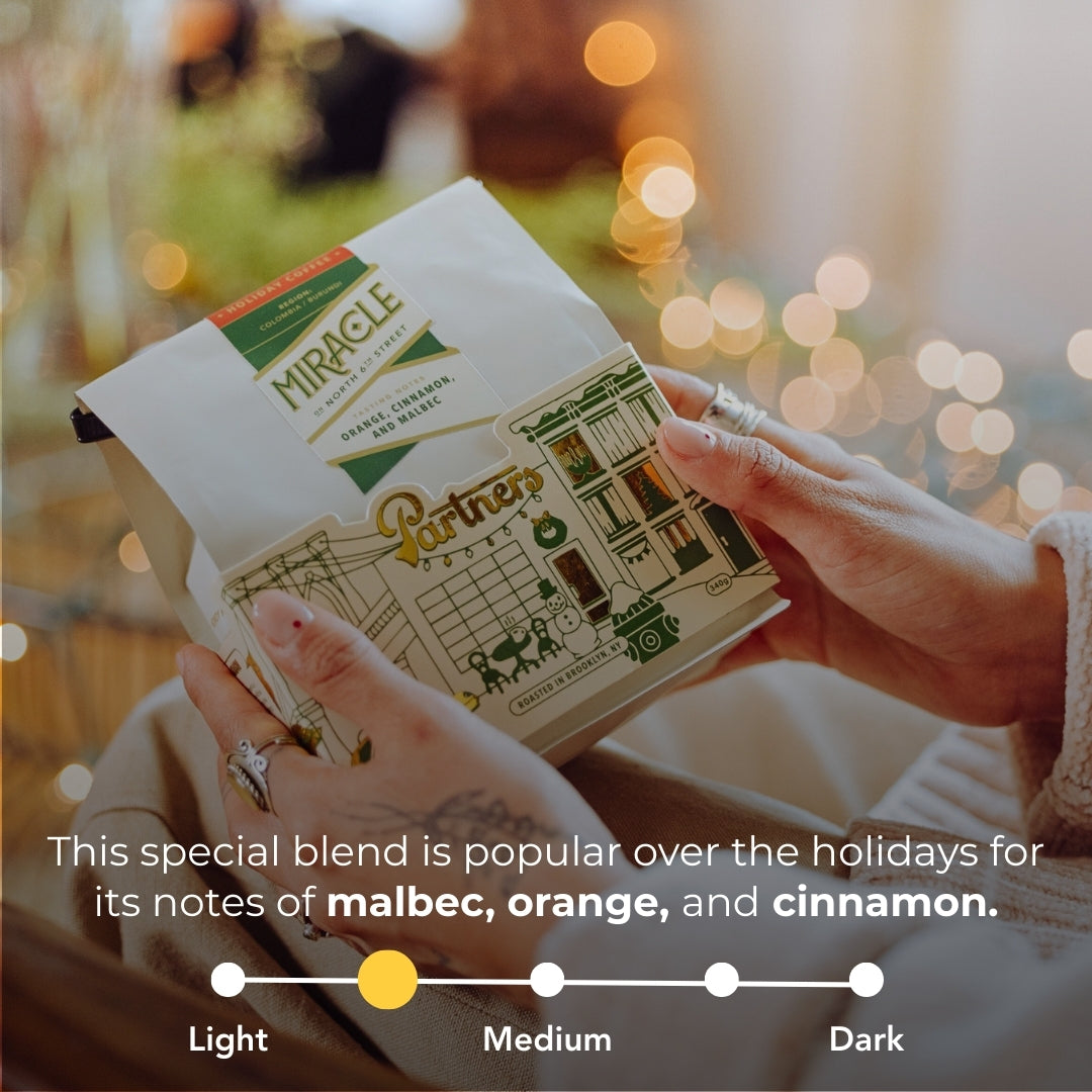 Front of Miracle On North 6th Street bag showing overlay: malbec, orange, cinnamon and roast-level against blurred lights