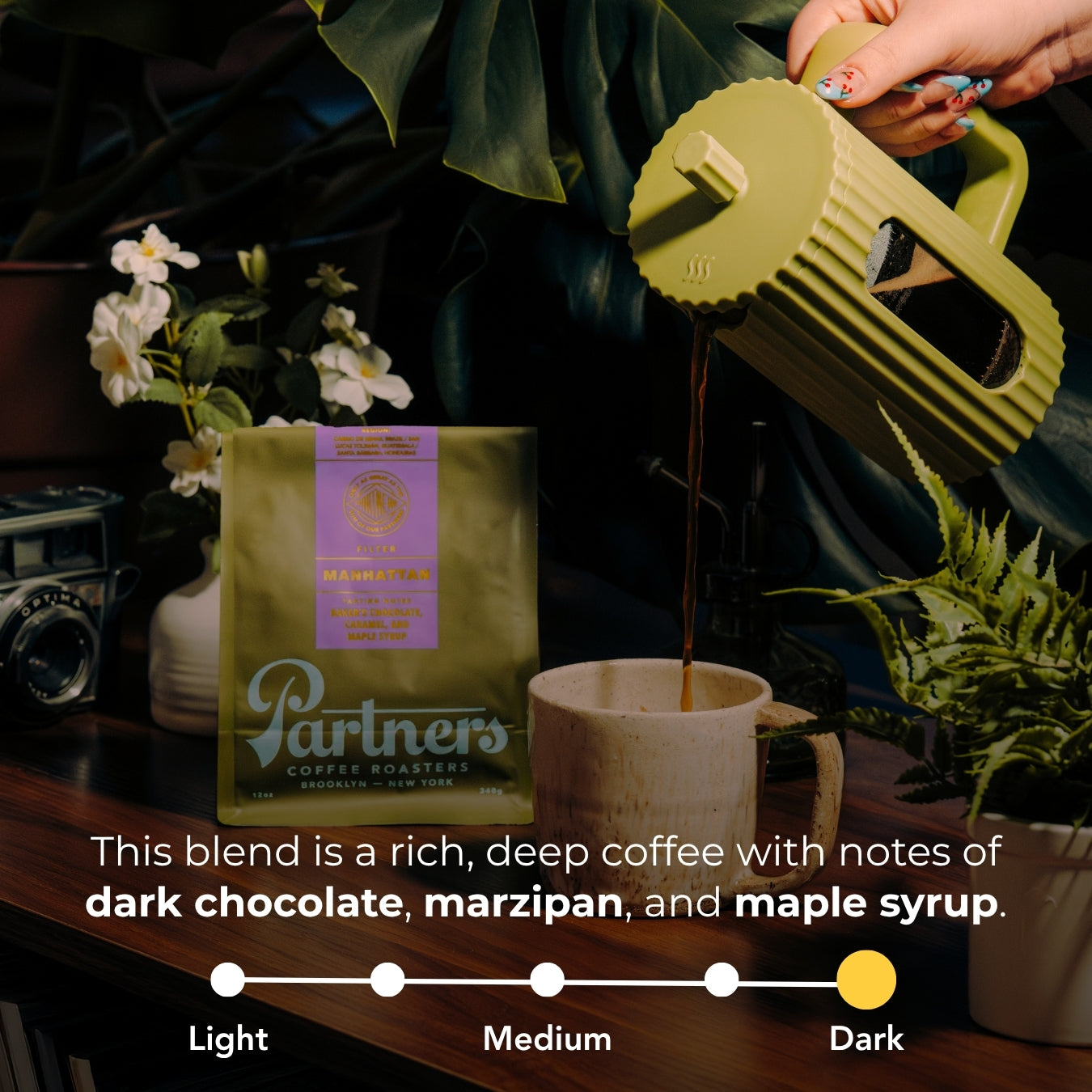 Photograph with overlaid text showing Manhattan blend tasting notes: dark chocolate, marzipan, and maple syrup, and a roast scale marked dark